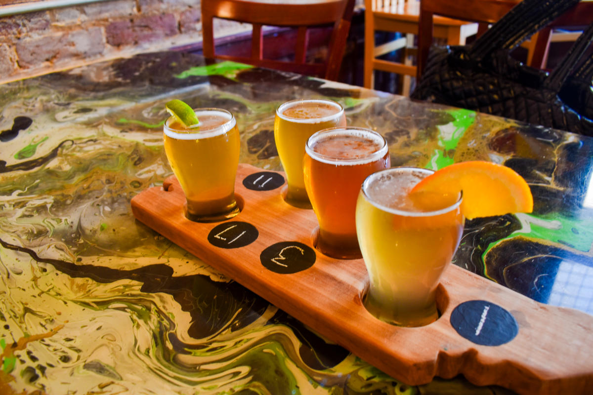 Black Creek Brewery 1 A cup of coffee, cream, and several slices of bread are displayed on a wooden serving tray